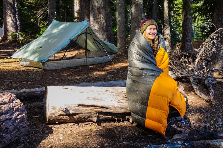 cô gái sử dụng túi ngủ khi đi cắm trại trong rừng