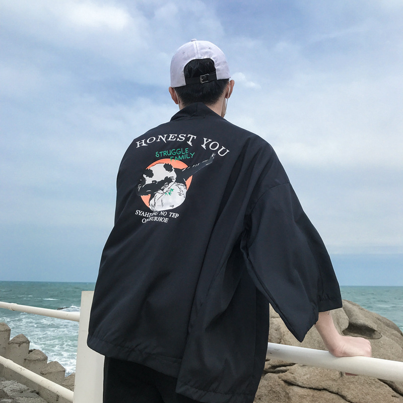 Chàng trai diện áo khoác màu đen đi biển cùng mũ lưỡi trai