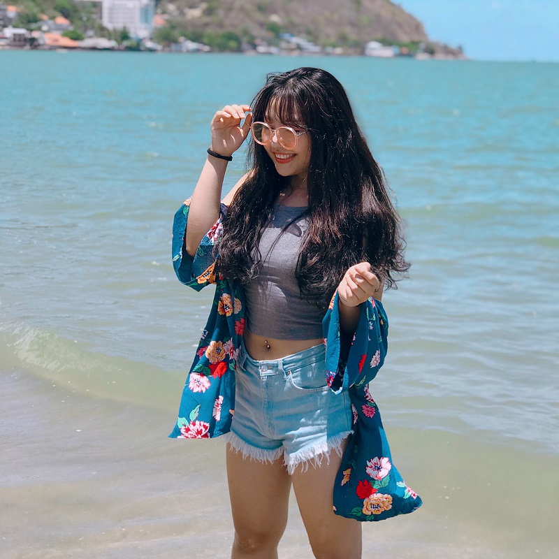 Cô gái mặc quần short áo croptop và áo kimono đi biển