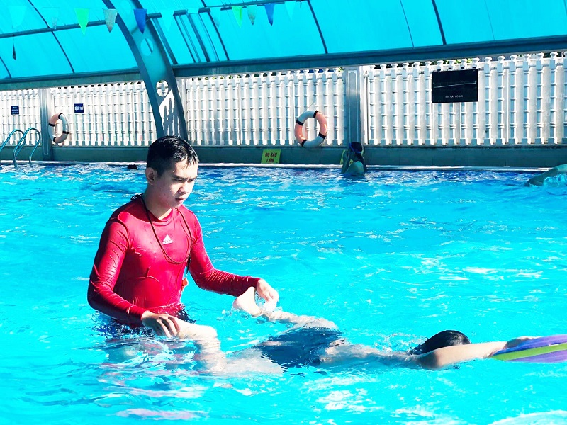HLV đang dạy em nhỏ tập bơi