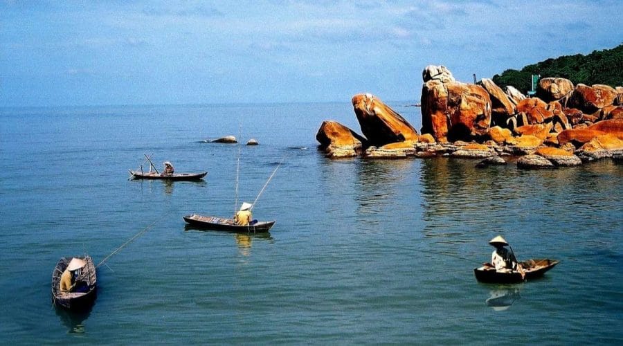Vùng vịnh nơi hòn đá bạc trong xanh, nhiều thuyền bè di chuyển xung quanh những vách đá